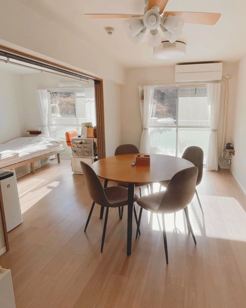 リノベーションされた団地のリビングダイニング。丸いテーブルに日が差し込み、明るく清潔感のある室内。